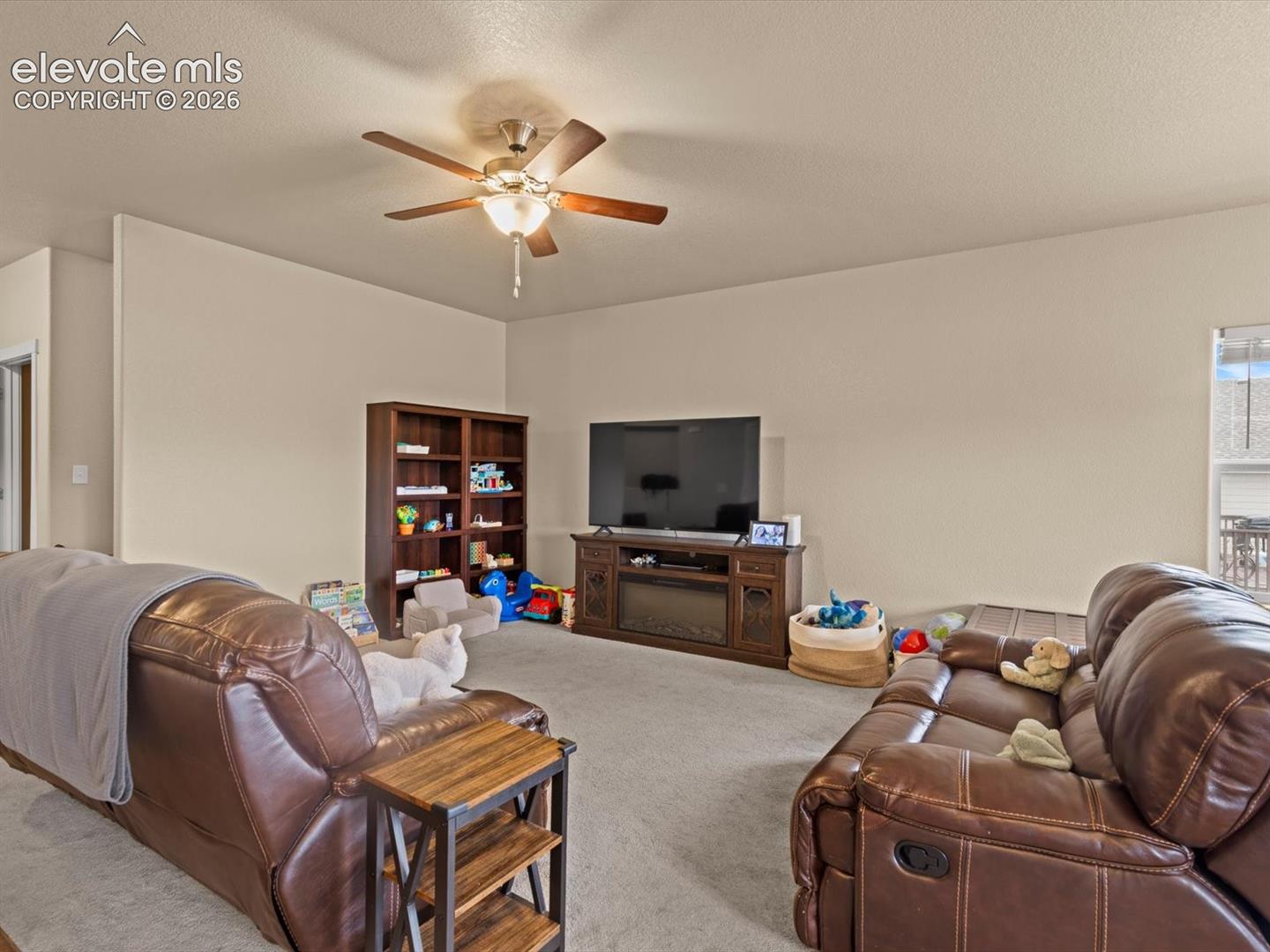 Living space featuring a ceiling fan, light-toned wall paint, and carpeted flooring