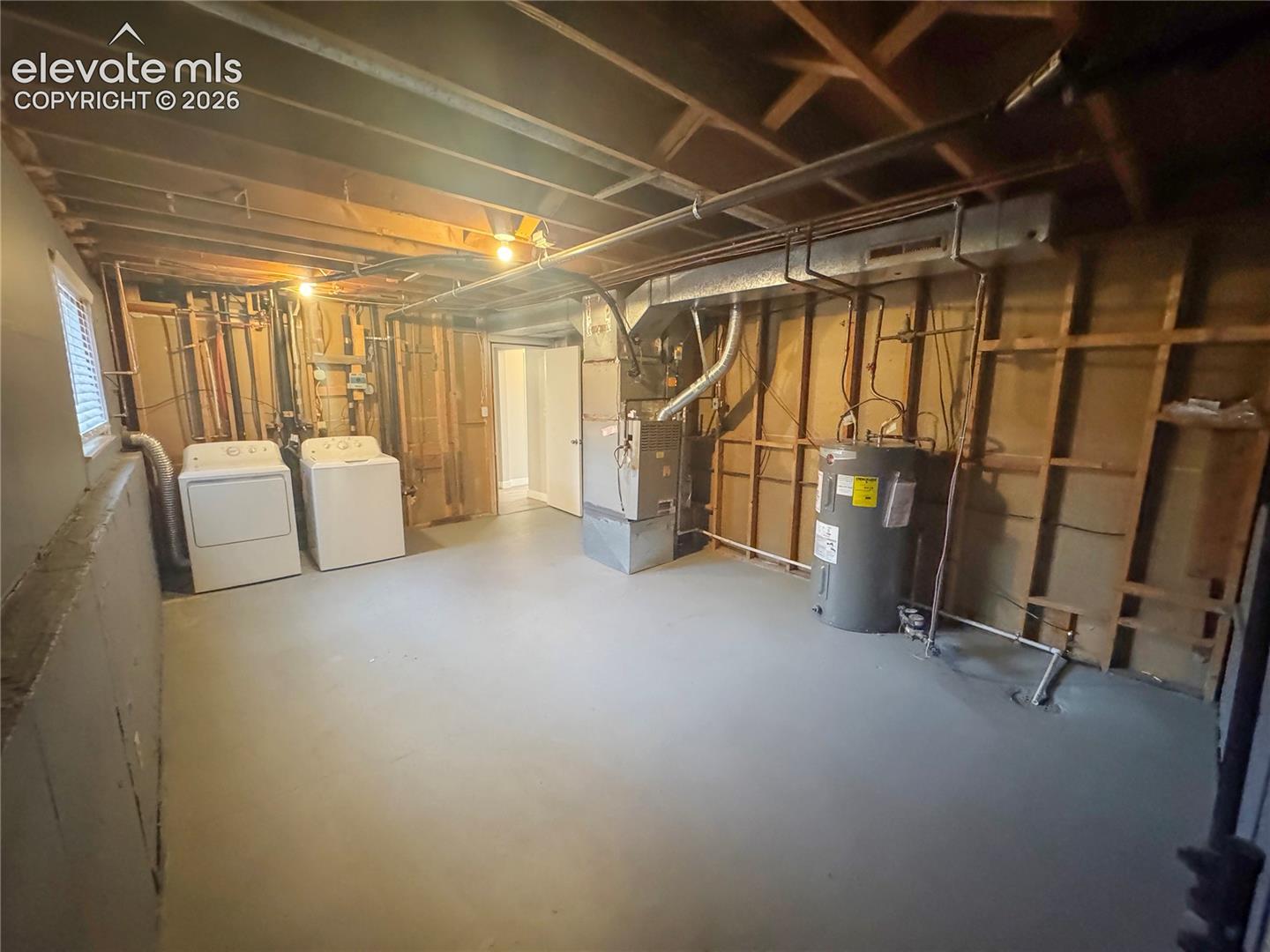 Utility area featuring painted concrete flooring, an exposed wood-joist ceiling, a forced-air heating system, and a hot water heater