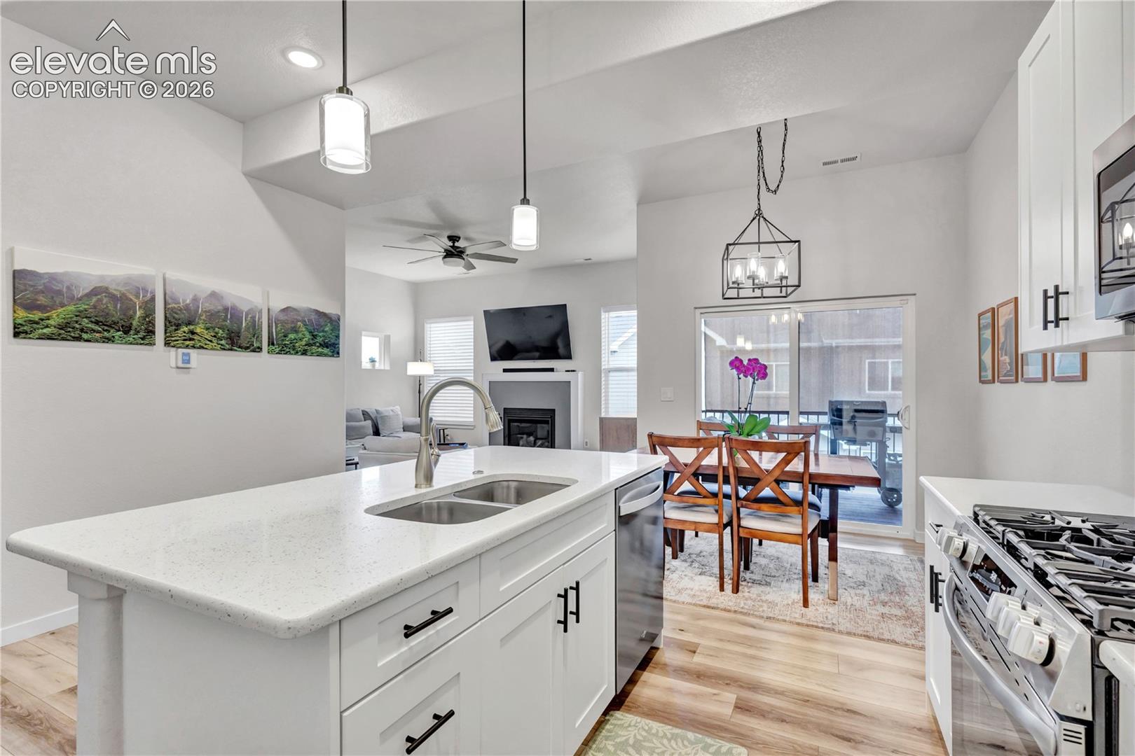 Kitchen island with a double basin sink, white cabinetry, and a light-toned countertop