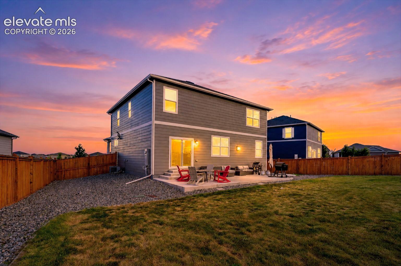 Sunset rear view of home and backyard.