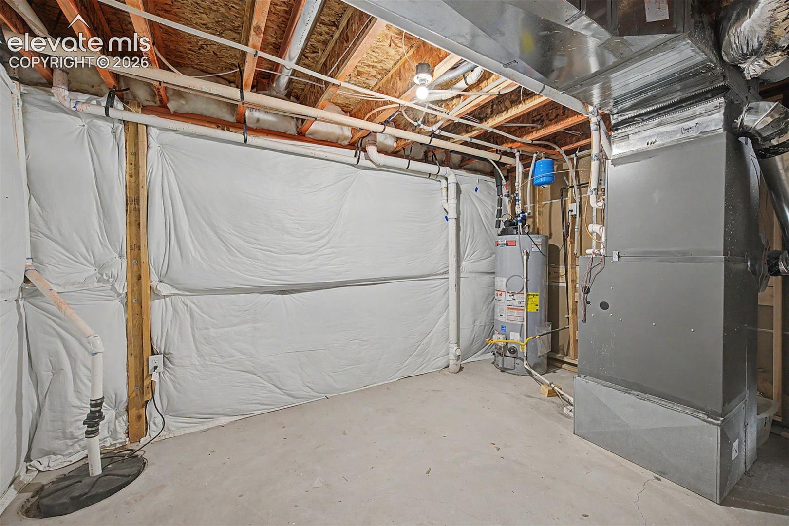 Unfinished basement space featuring a water heater, furnace, exposed ceiling joists, and concrete flooring
