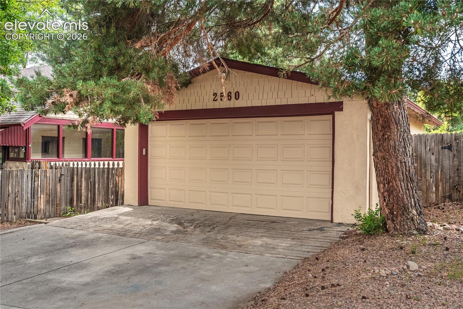 Detached garage with Power and paneled door, stucco exterior, and accent trim