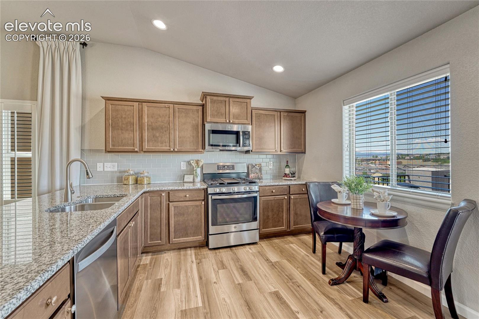 The well-designed kitchen combines function and style with granite countertops, stainless steel appliances including a brand new dishwasher, subway tile backsplash, and a sunny breakfast nook.
