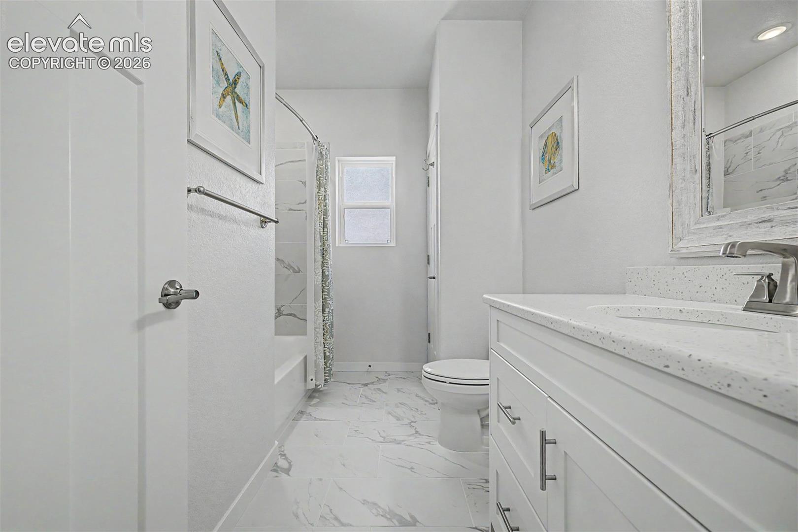 The shared hall bath is bright and polished, with marble-look tile floors, a quartz vanity, and a dedicated linen closet that gives well beyond what you'd expect from a secondary bath.