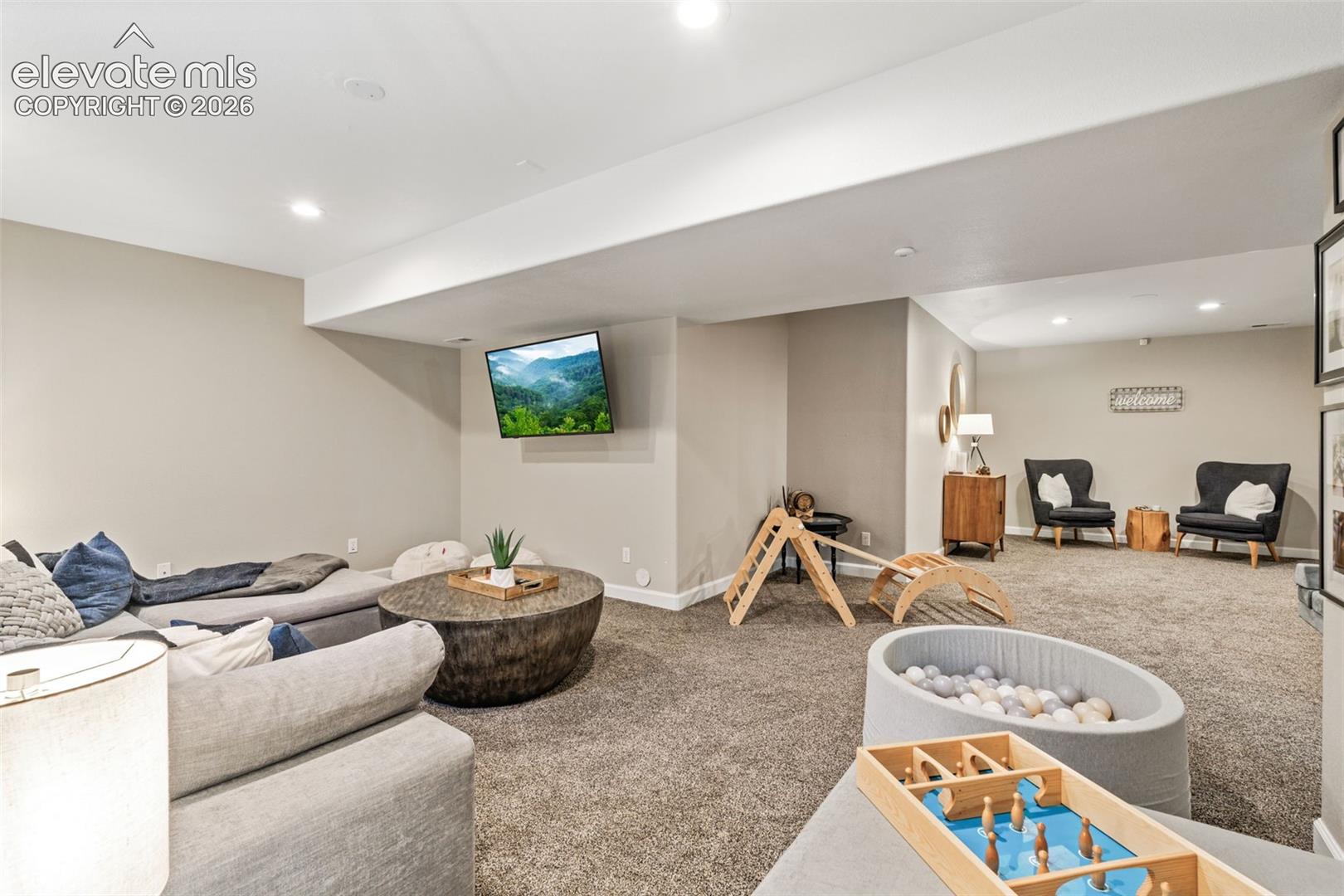 Open-concept interior space featuring neutral wall tones, recessed lighting, and wall-to-wall carpeting