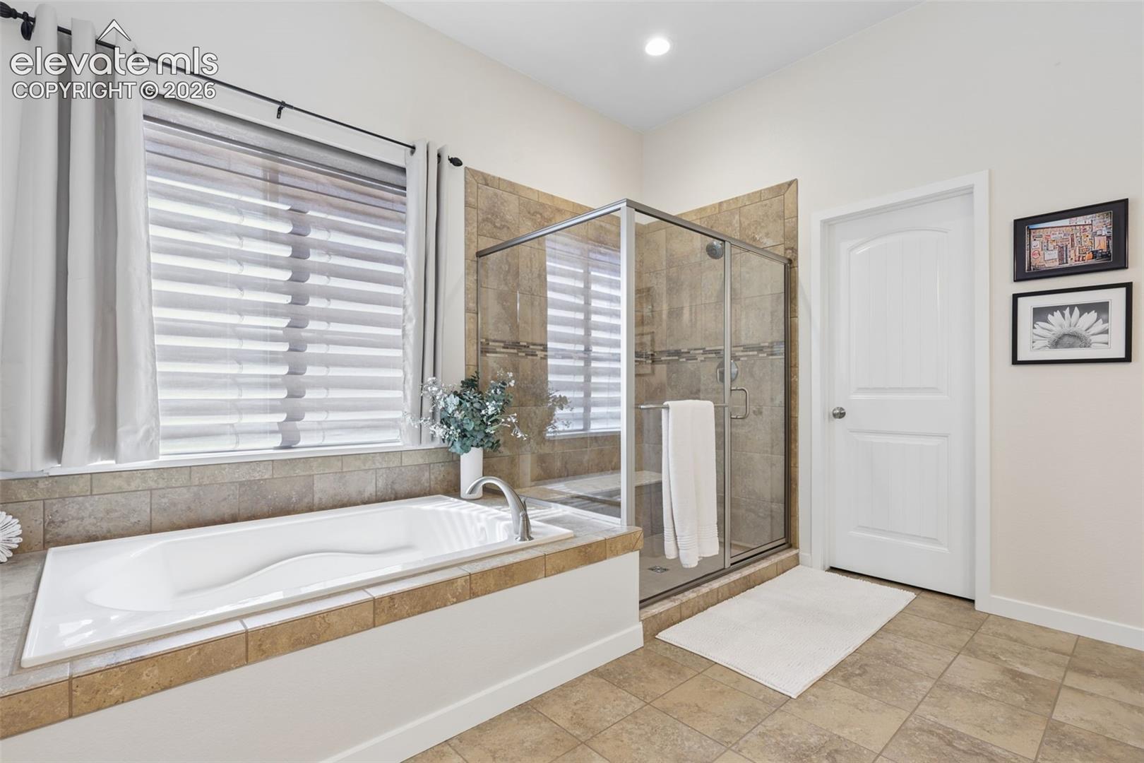 Walk-in shower with clear glass enclosure and tile surround