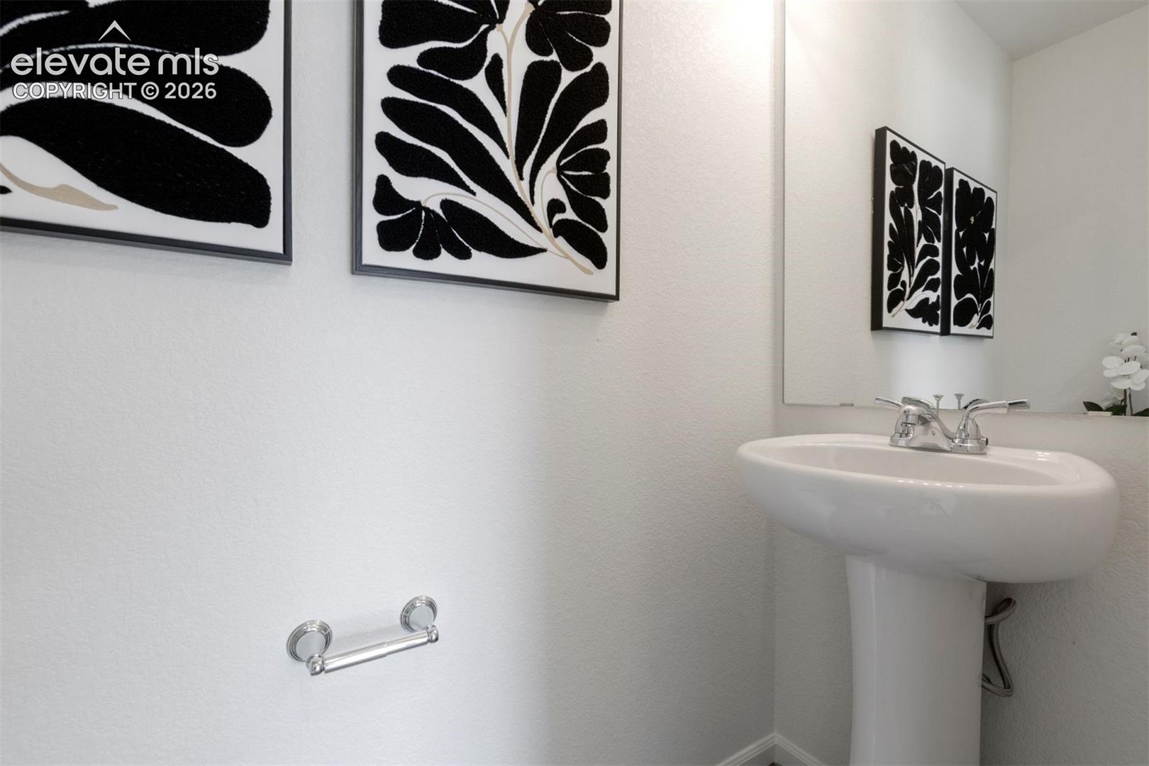 Pedestal sink with polished chrome fixtures and a frameless wall mirror
*photos of a model home*