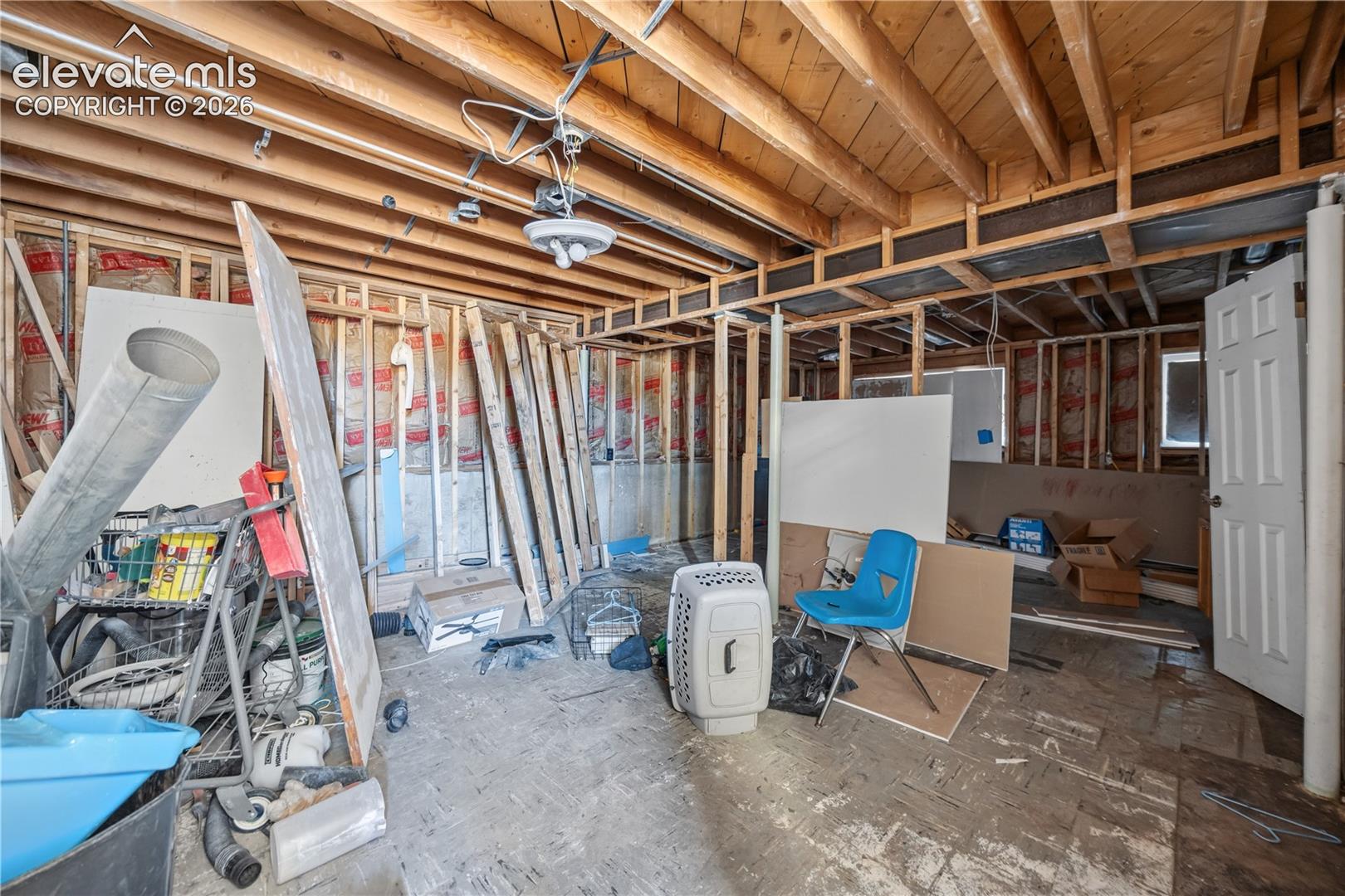 Unfinished interior space featuring exposed wood-framed joists, exposed wall studs, and insulation
