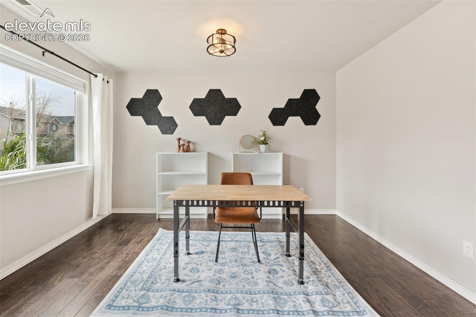 Large window with white trim, wood-finish flooring, and a flush mount ceiling light fixture