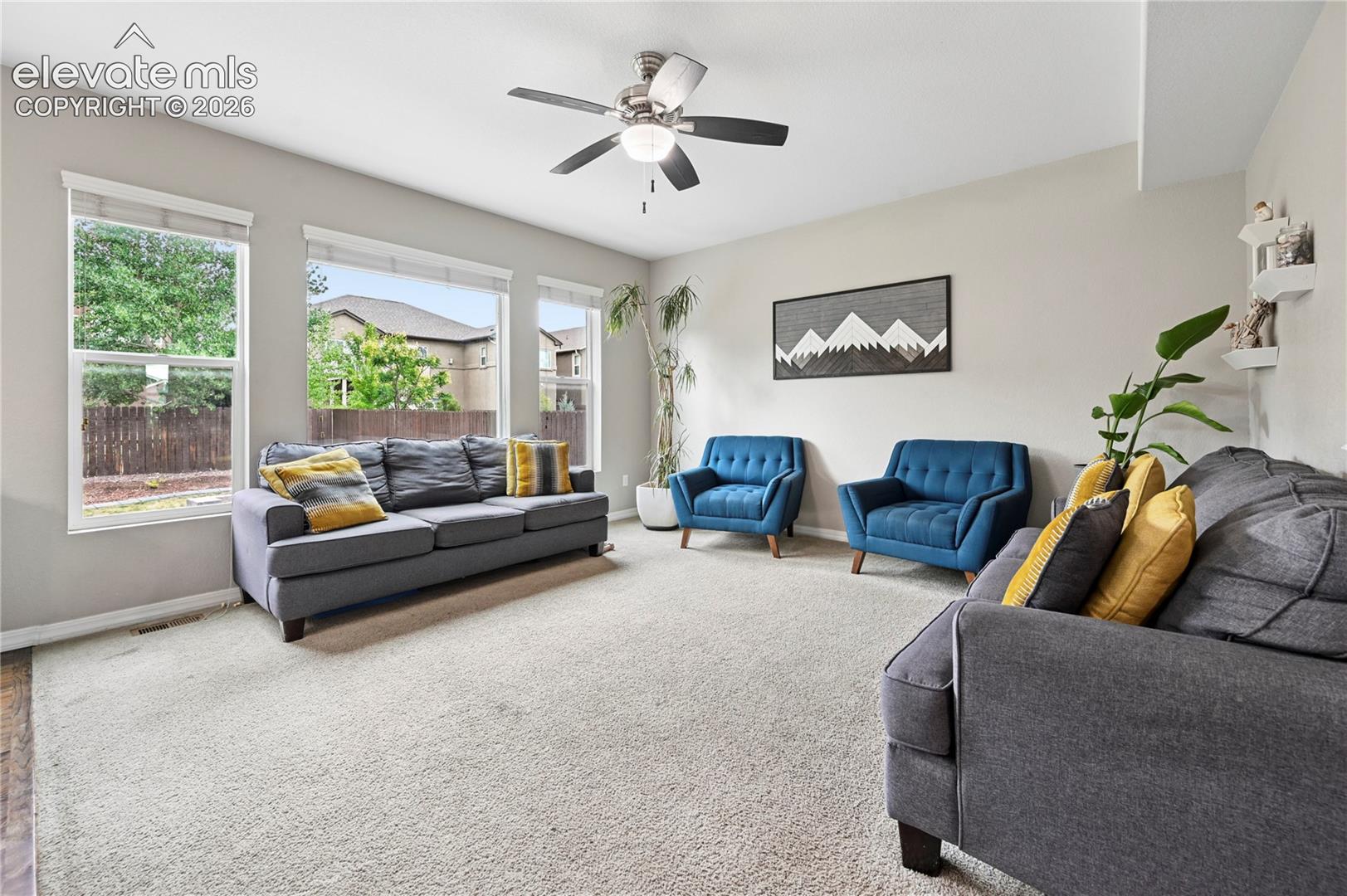 The living room enjoys so much daylight from a whole wall of windows that open to the backyard.  The warm colors make for easy to coordinate interior decor and give a soft, cozy feel even in larger spaces.