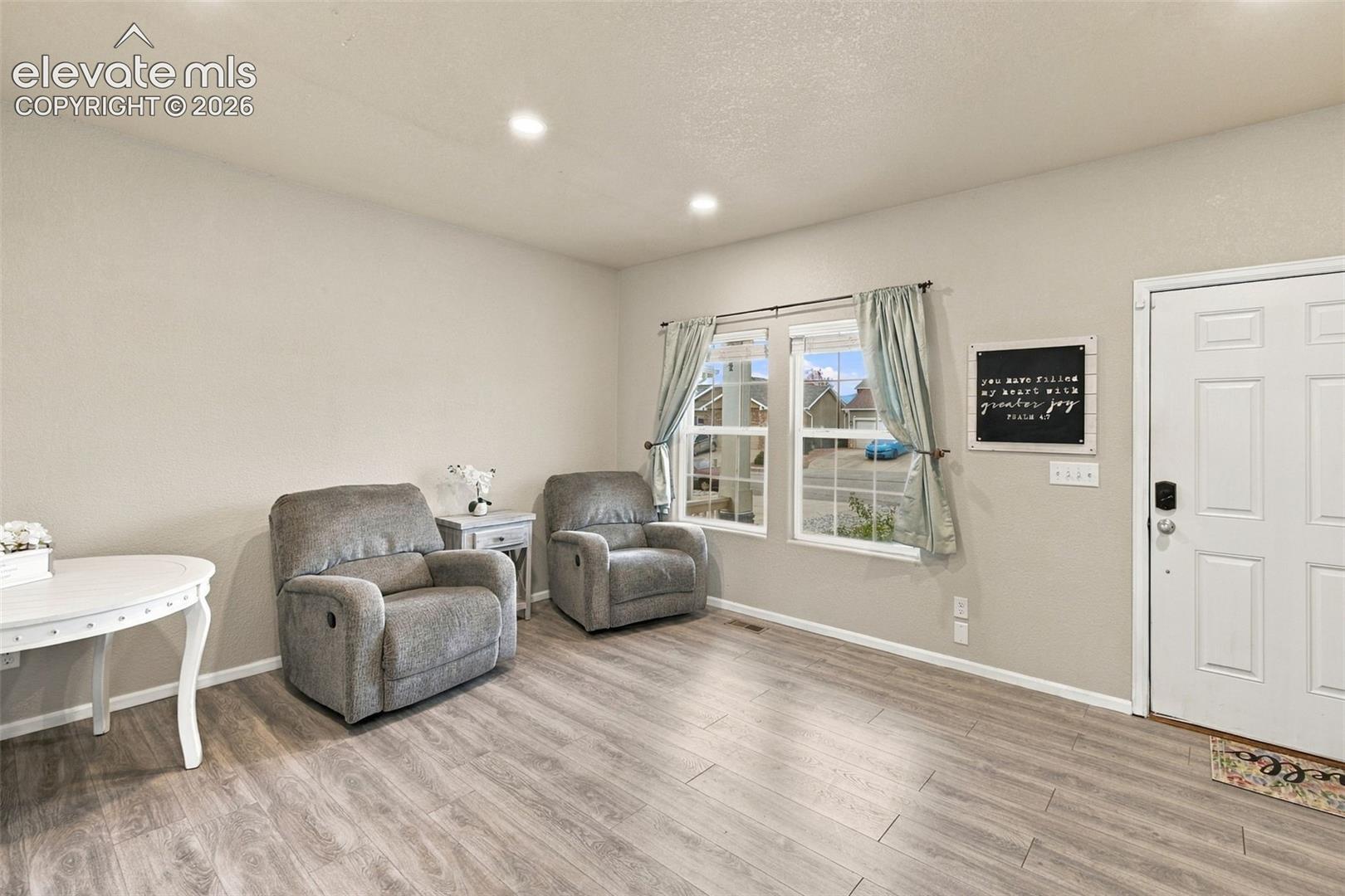 Wood-finish flooring, recessed lighting, neutral wall paint, and multi-pane windows