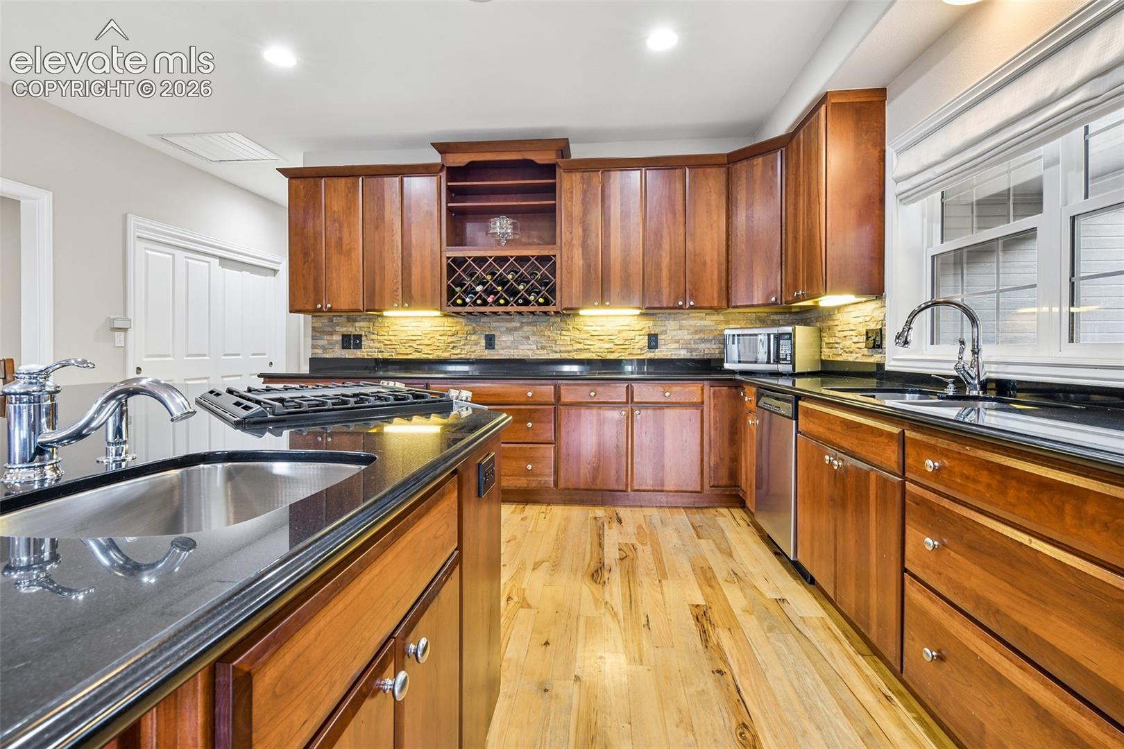 Stacked stone backsplash, deep drawers, and wide pantry closet