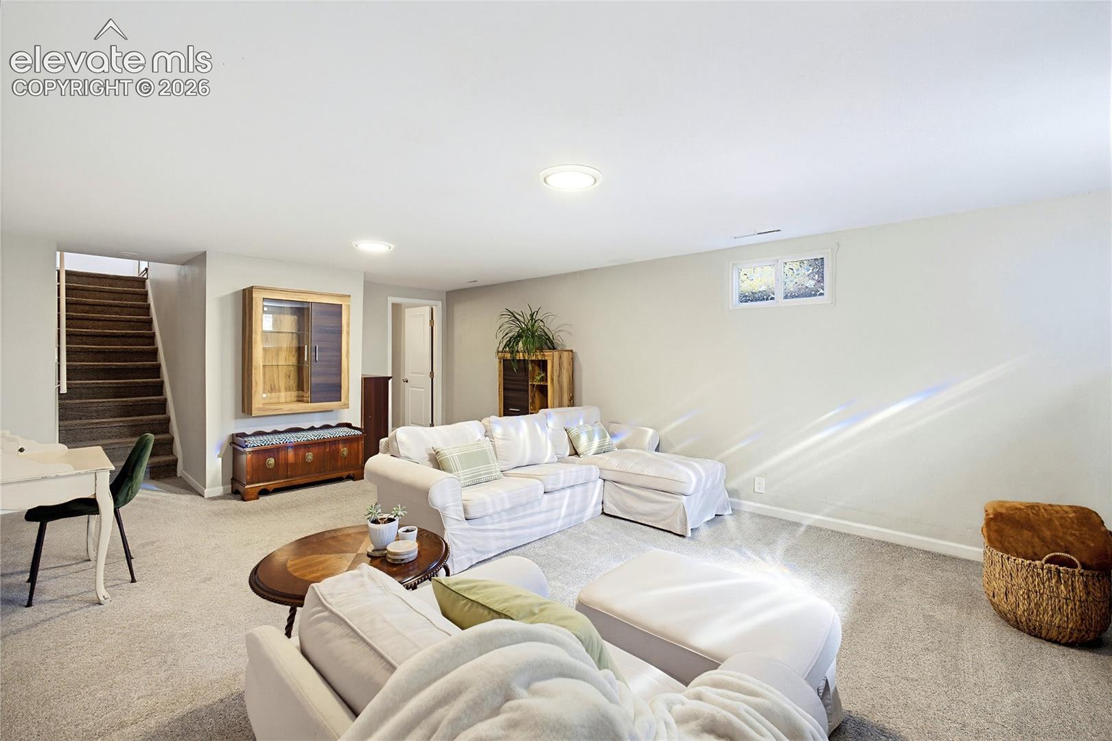 Finished interior space featuring neutral wall-to-wall carpeting, recessed ceiling lighting, and a built-in recessed display cabinet