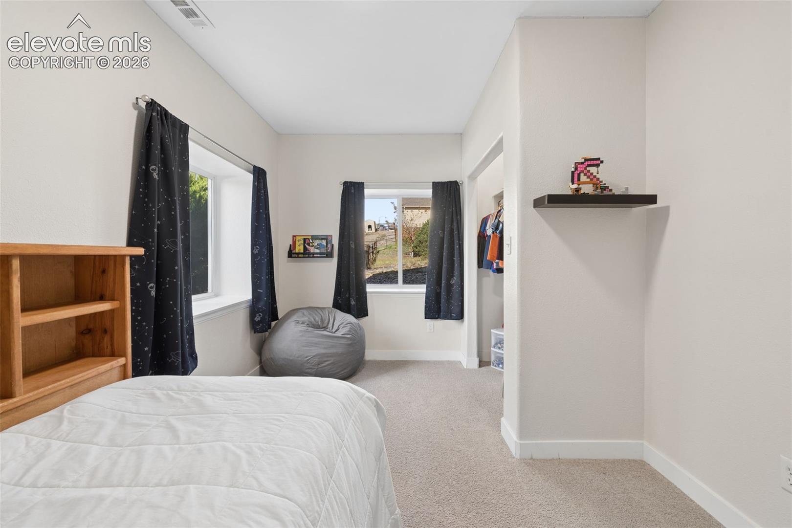 Carpeted room with multiple windows providing natural light