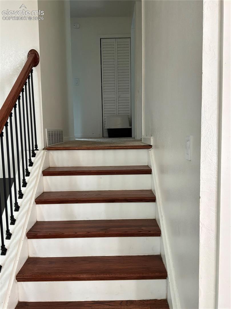 Staircase featuring wood-finish treads and white risers
