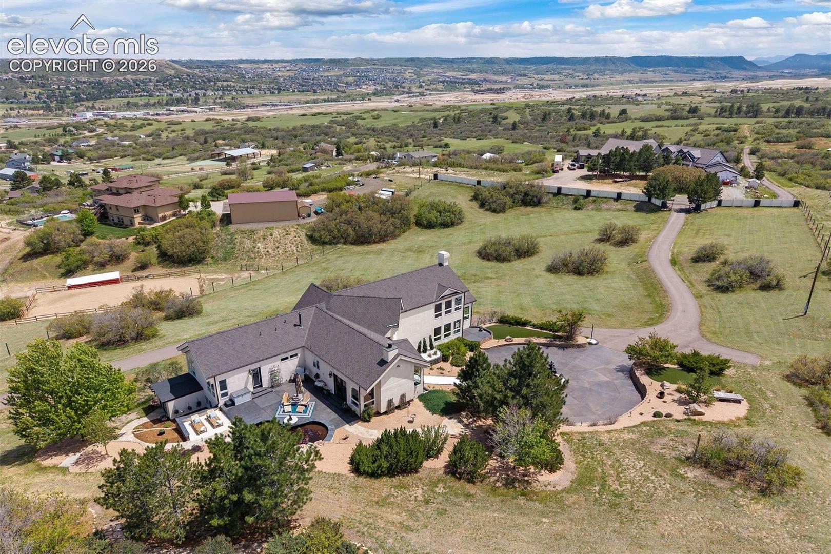 Aerial overview of the full estate showing the main house, patio, water feature, motor court, and acreage.