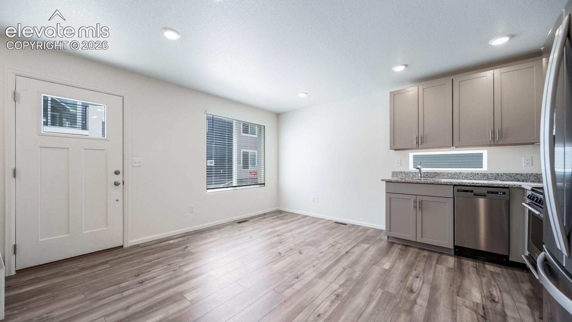 Kitchen featuring shaker-style 
cabinetry, stone-finish countertops, stainless steel appliances, and wood-finish flooring
*photos of a model home*