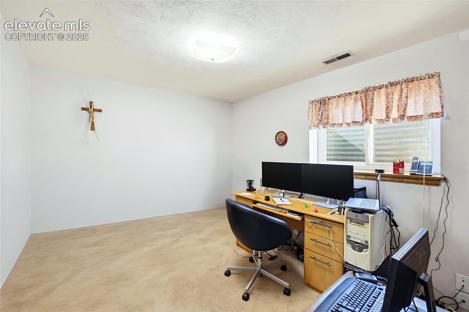 Carpeted flooring, white walls, and a window with a wood sill