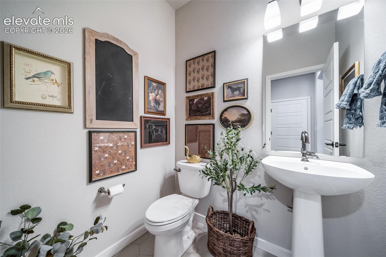 Pedestal sink with chrome faucet, large mirror, and three-light vanity fixture
*Photos of a model home*
