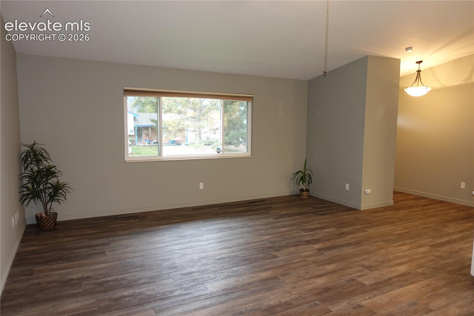 Living room and front entry door to right with vaulted ceiling with nice updated-LVP flooring, interior paint, lights and ceiling fan!