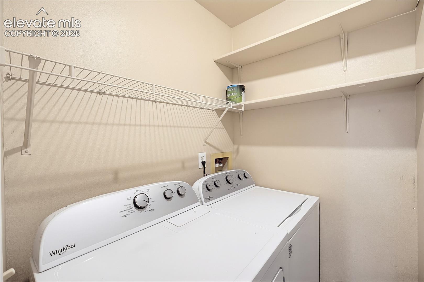 The Laundry Room features built-in shelves and  a washer and dryer.