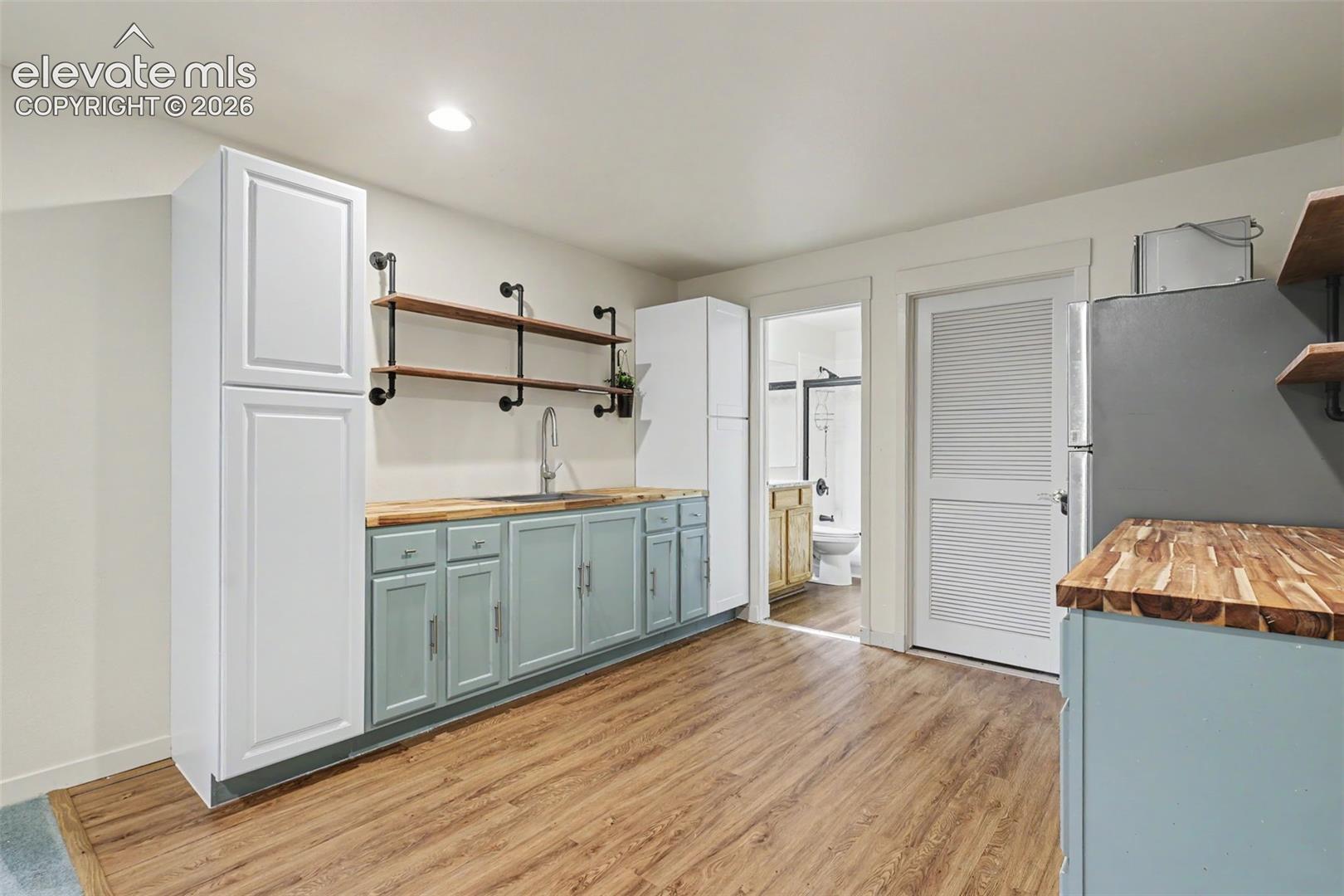 Full kitchen-style setup featuring a wood-finish floor and white walls