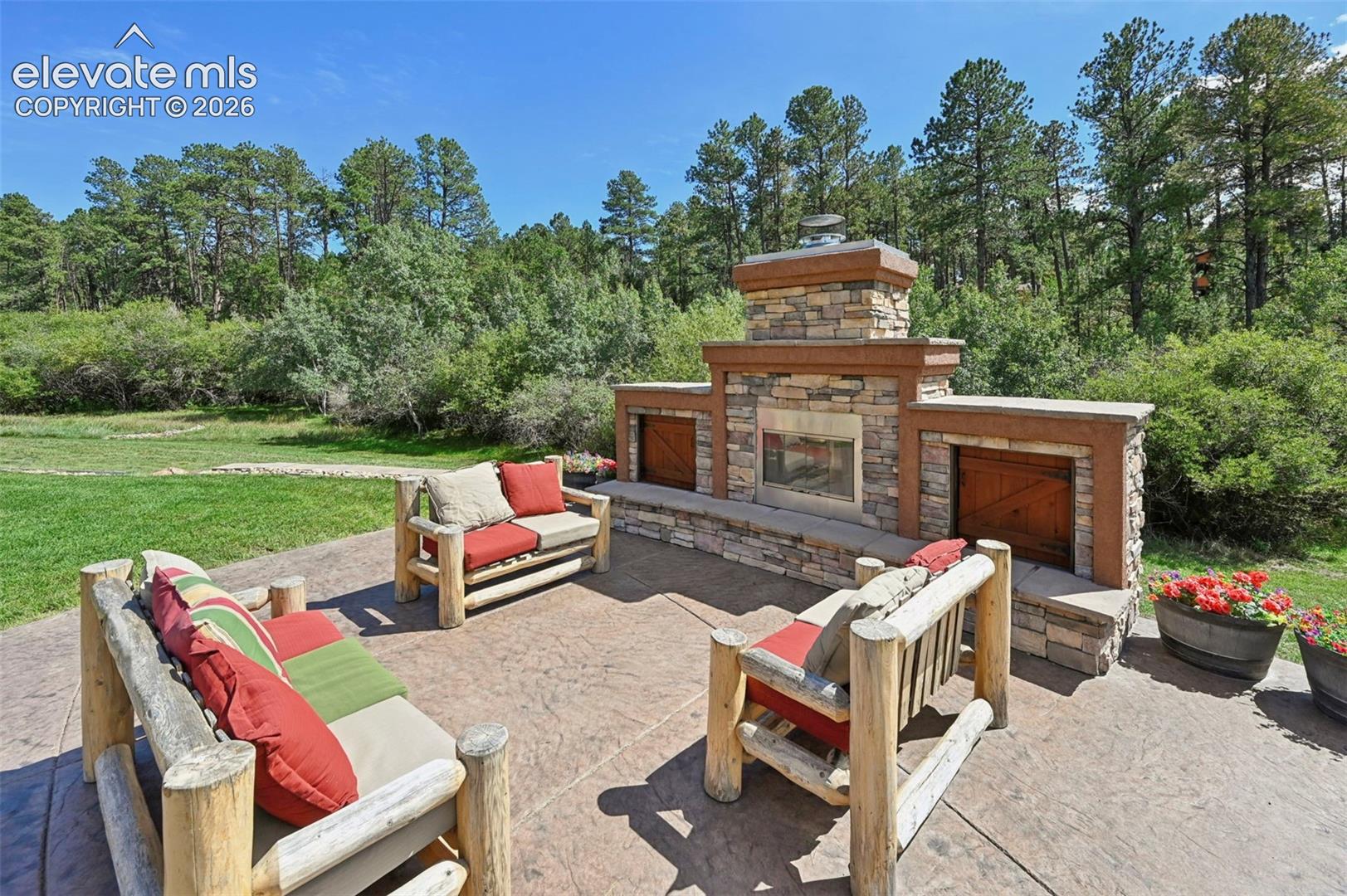 Outdoor wood furniture at fireplace conveys!