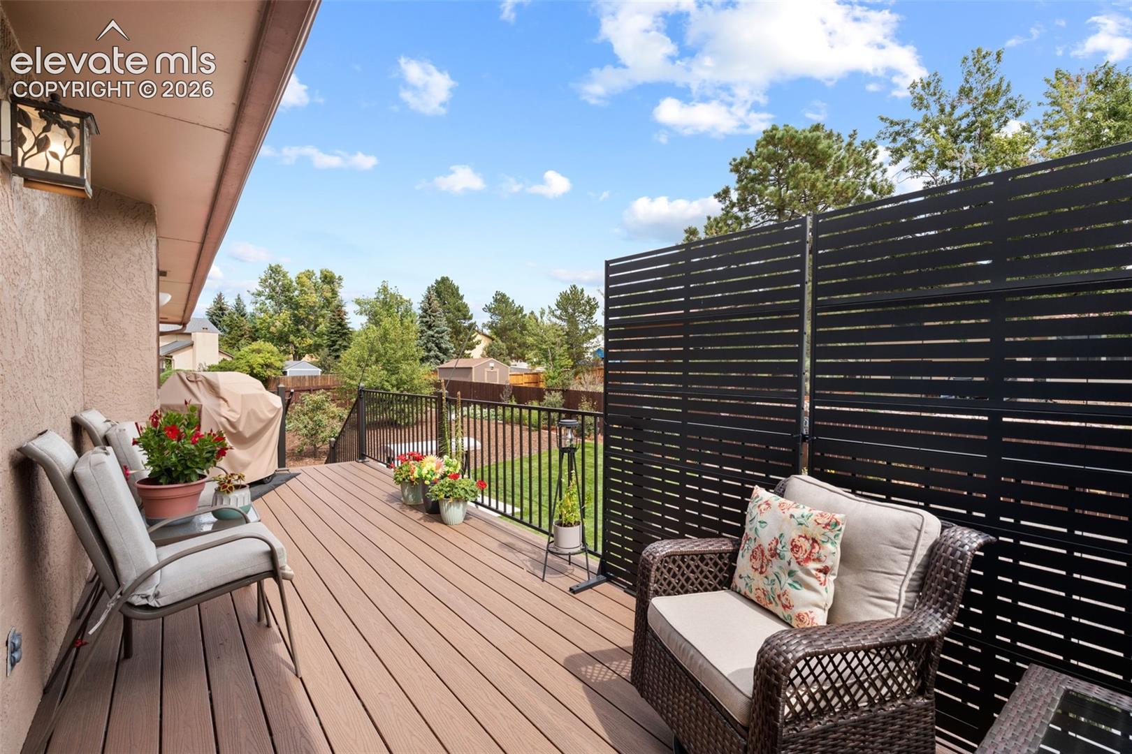 Elevated composite deck featuring black metal railings and a privacy screen