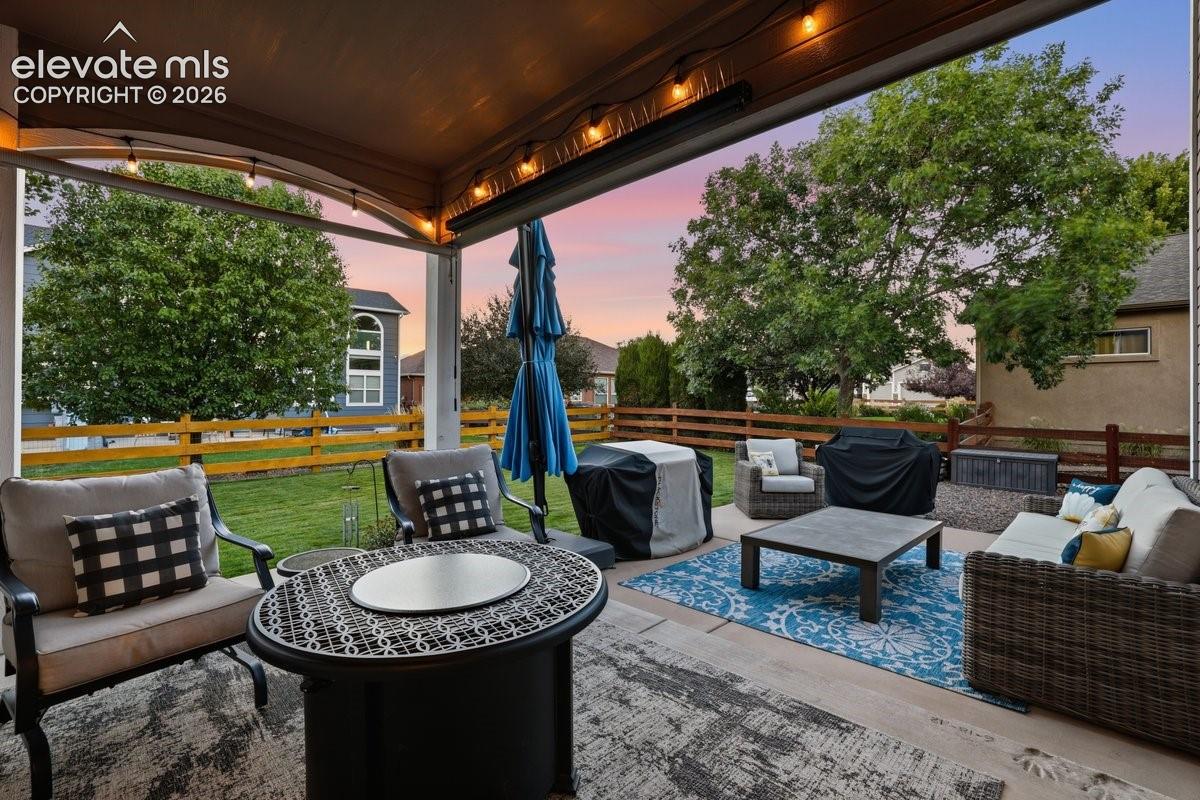 private covered back patio overlooking a well manicured backyard space