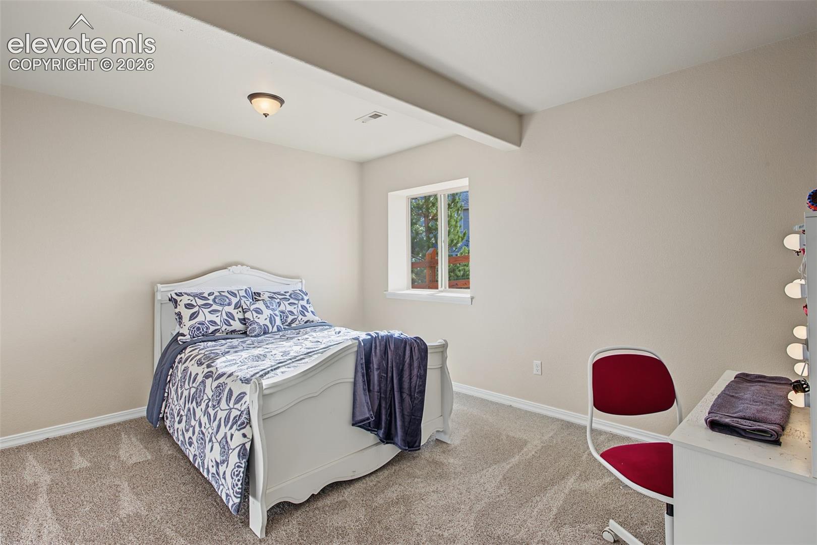Neutral wall tones, wall-to-wall carpeting, and a recessed ceiling design featuring a centralized flush-mount light fixture