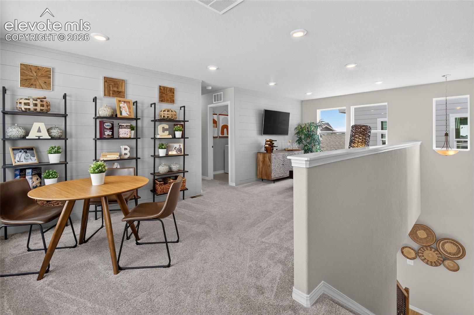 Horizontal shiplap accent wall, neutral carpeting, recessed ceiling lighting, and half-wall stair enclosure