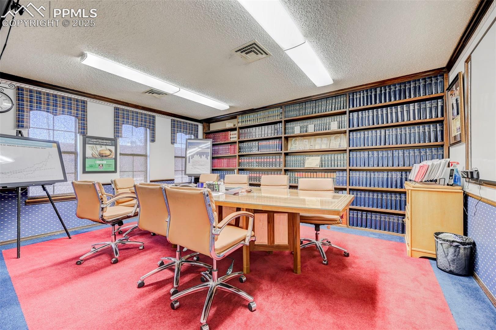 Carpeted office space featuring a textured ceiling and ornamental molding