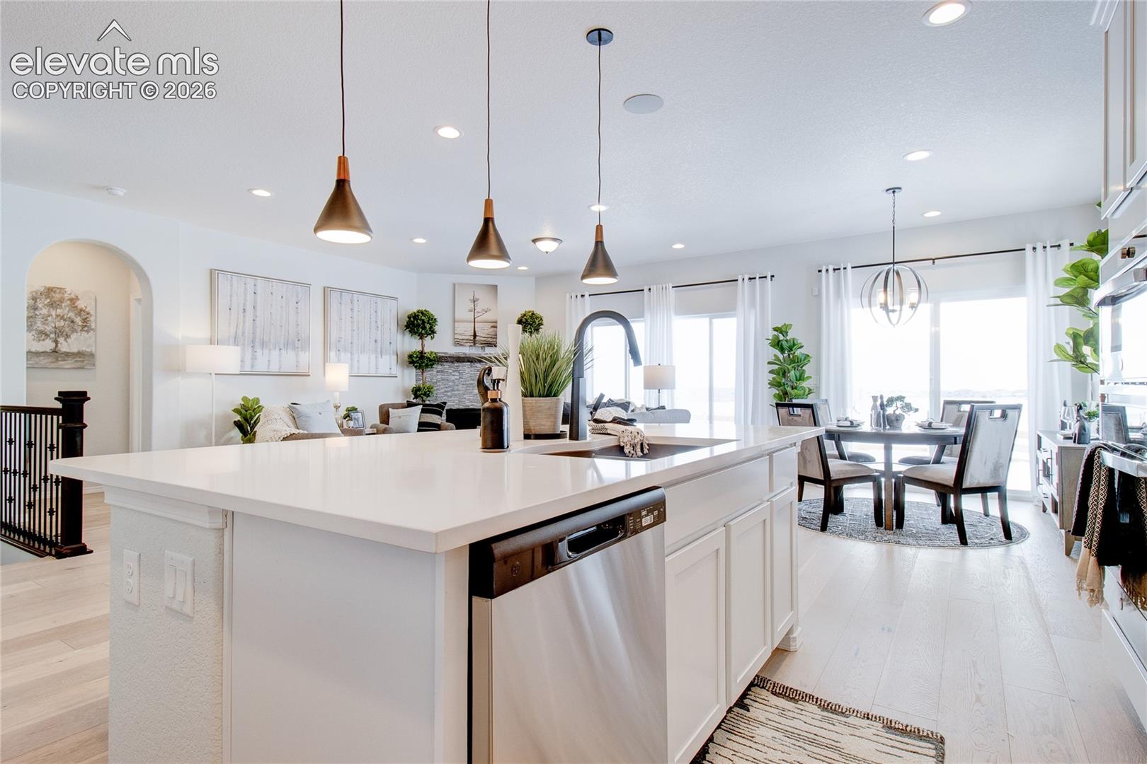 Kitchen island featuring a white countertop, undermount sink, and stainless steel dishwasher