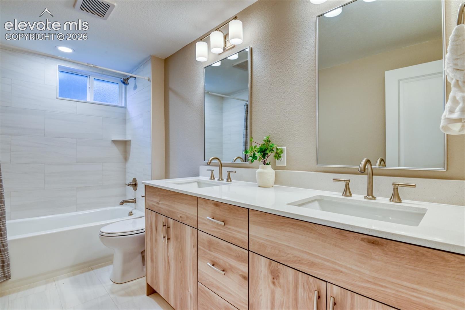 Dual vanity with wood-finish cabinetry and integrated sinks