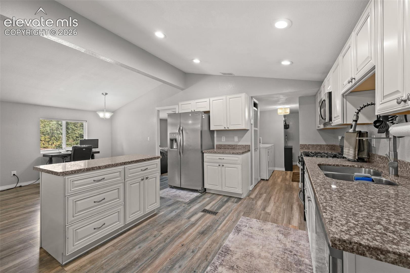 Kitchen featuring white shaker-style cabinetry, stone-finish countertops, stainless steel appliances, recessed lighting, and wood-finish flooring