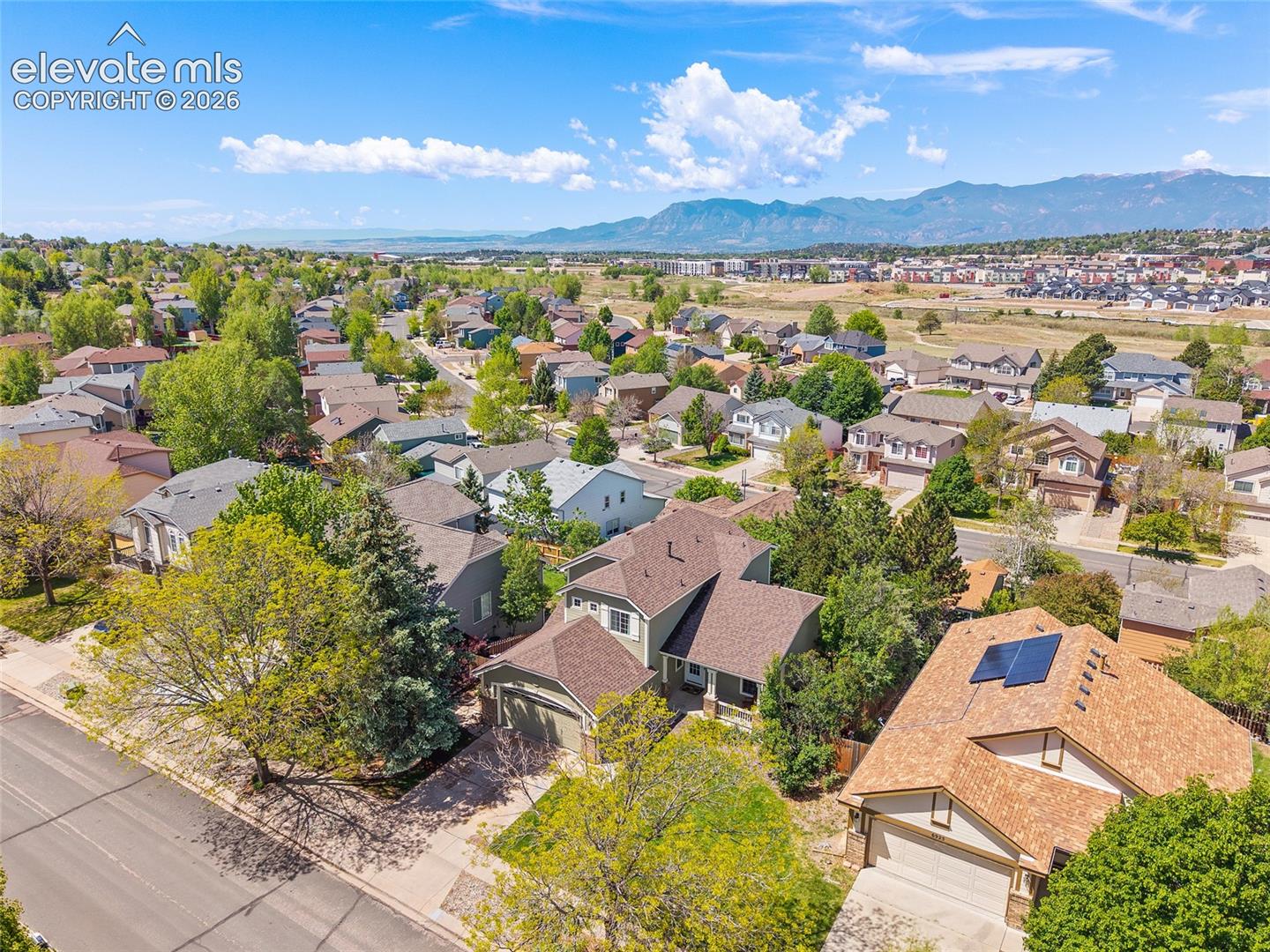 Aerial perspective highlighting a residential neighborhood with a backdrop of mountains