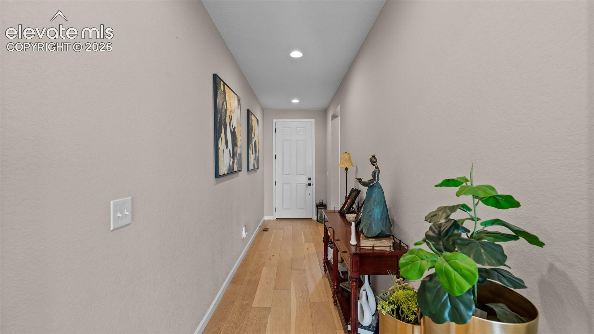 Recessed lighting illuminates wood-finish flooring