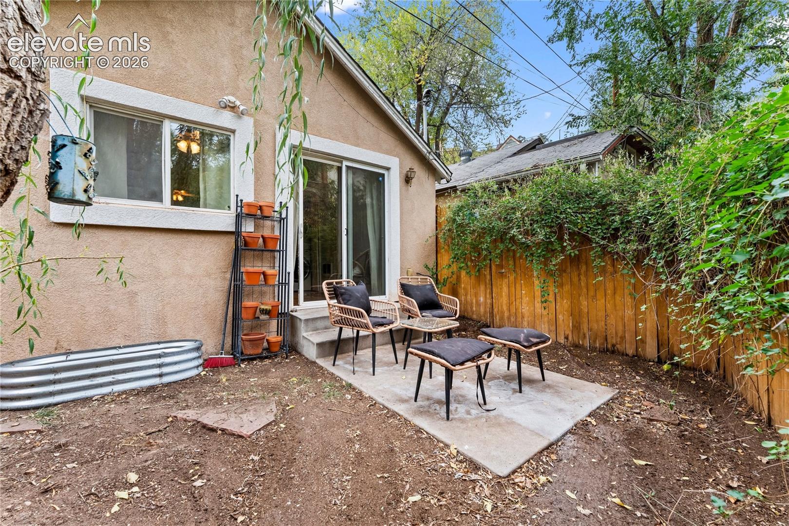 Exterior concrete patio featuring sliding glass doors and wood privacy fencing