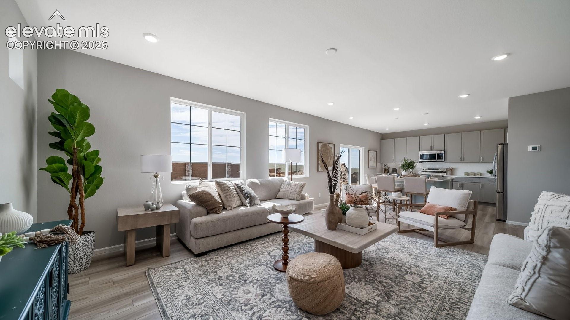 Open-concept living space with recessed lighting, wood-finish flooring, and multiple windows
*photos of a model home*