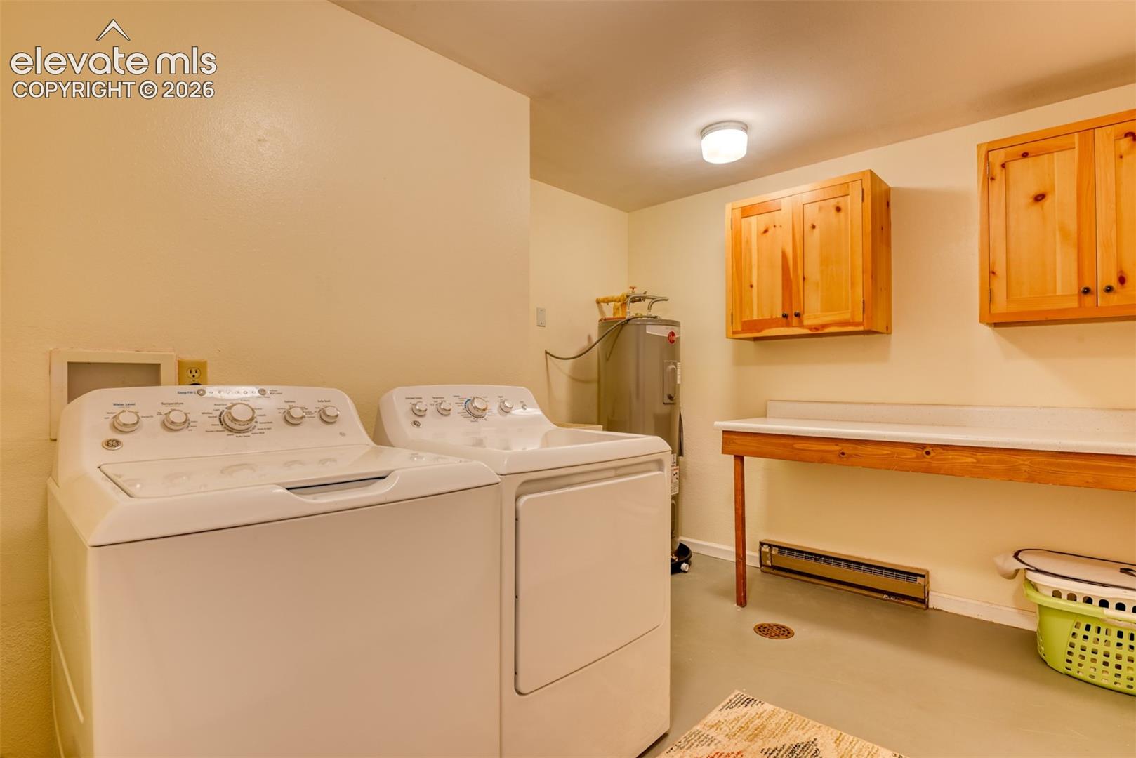 Laundry room has utility sink not shown, folding table, and storage cabinets and located in the basement next to the three bedrooms. 
