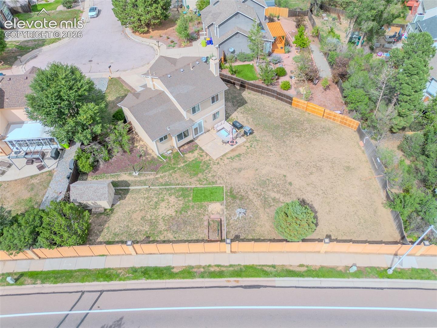 Spacious 1/4 acre backyard featuring a multi-level deck, storage shed, and perimeter fencing