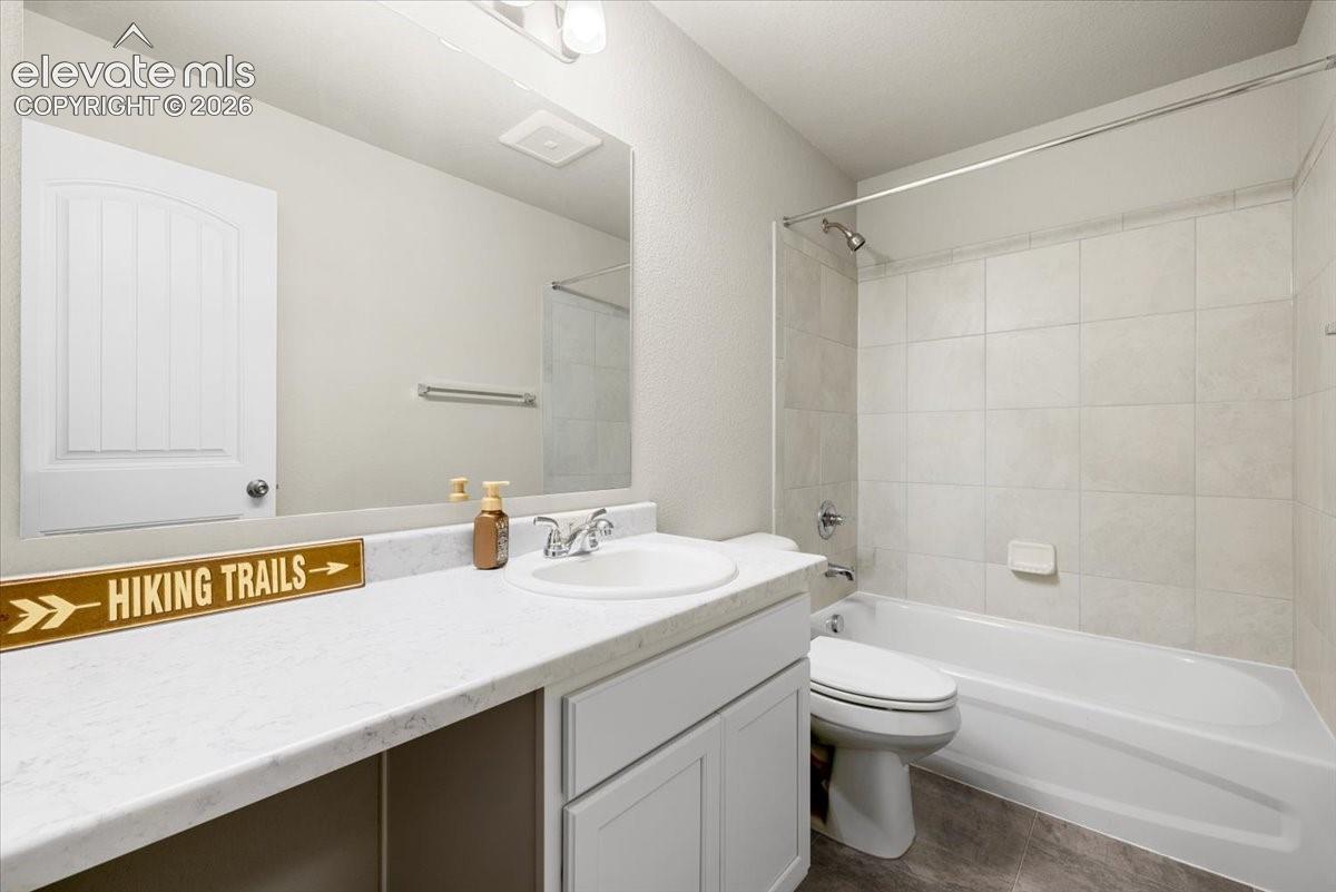 Bathroom featuring a single vanity with a white countertop, an undermount sink, and a chrome faucet