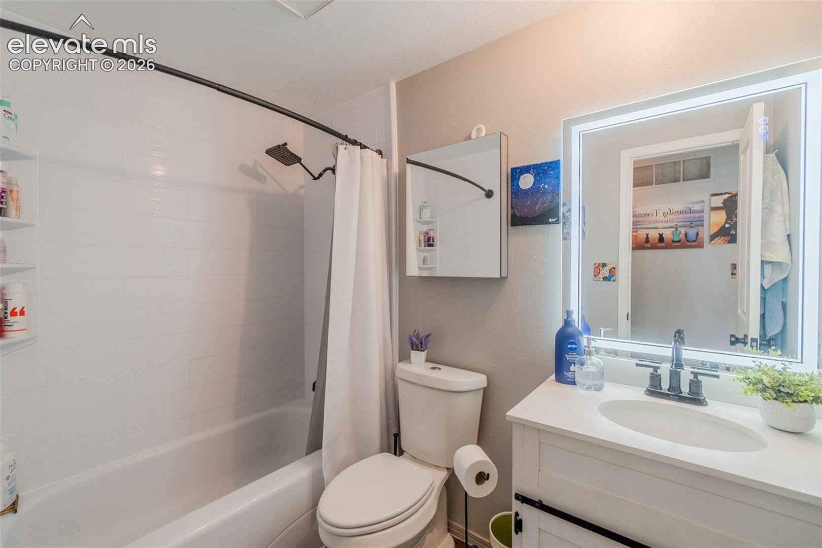 Bathroom vanity with white countertop, undermount sink, and dark-finish faucet, fancy mirror