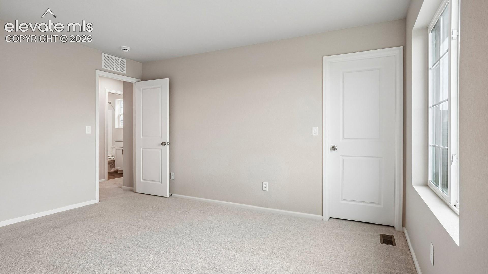 Neutral wall finishes, light-colored carpeting, white interior doors, and a multi-pane window
*photos of a model home*