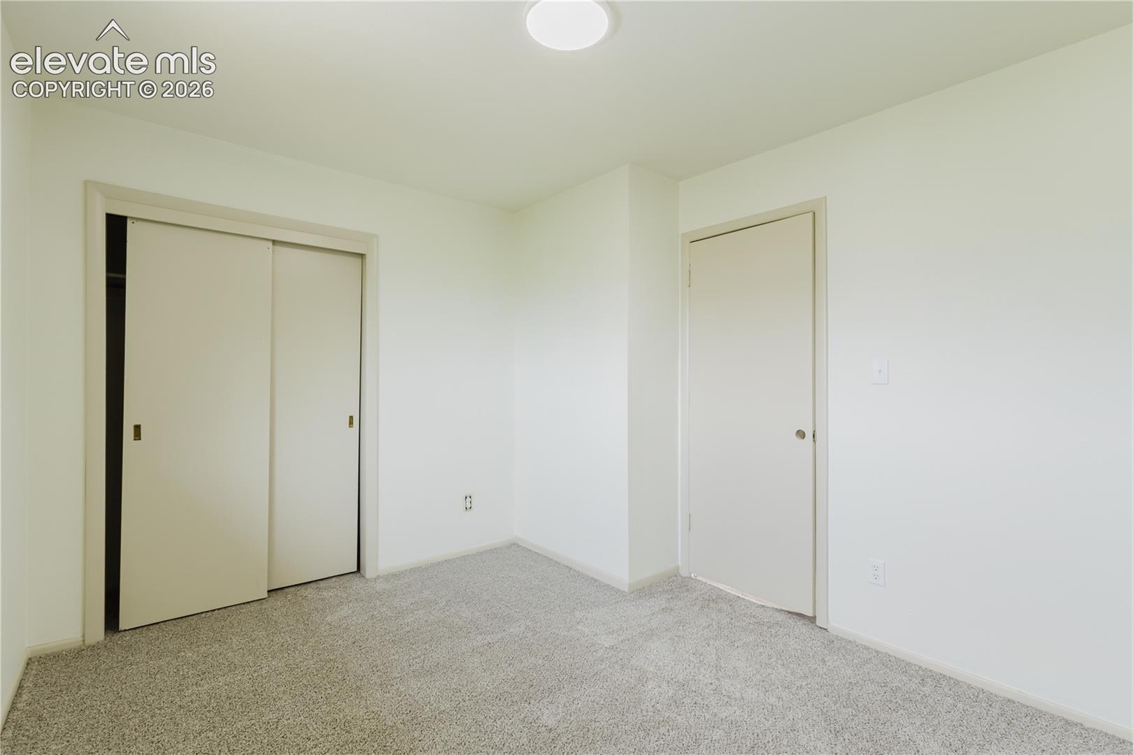Neutral-toned walls complement the light-colored carpet flooring