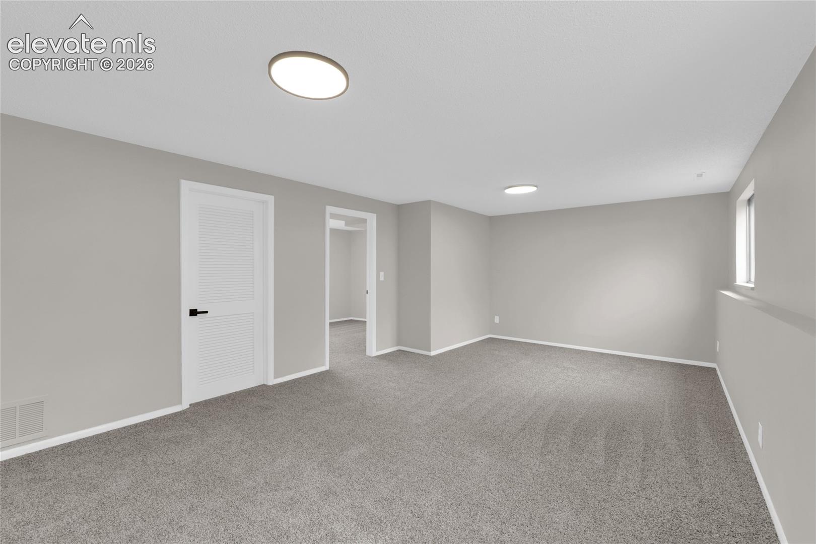 Carpet flooring, recessed lighting, white baseboards, louvered door, and window