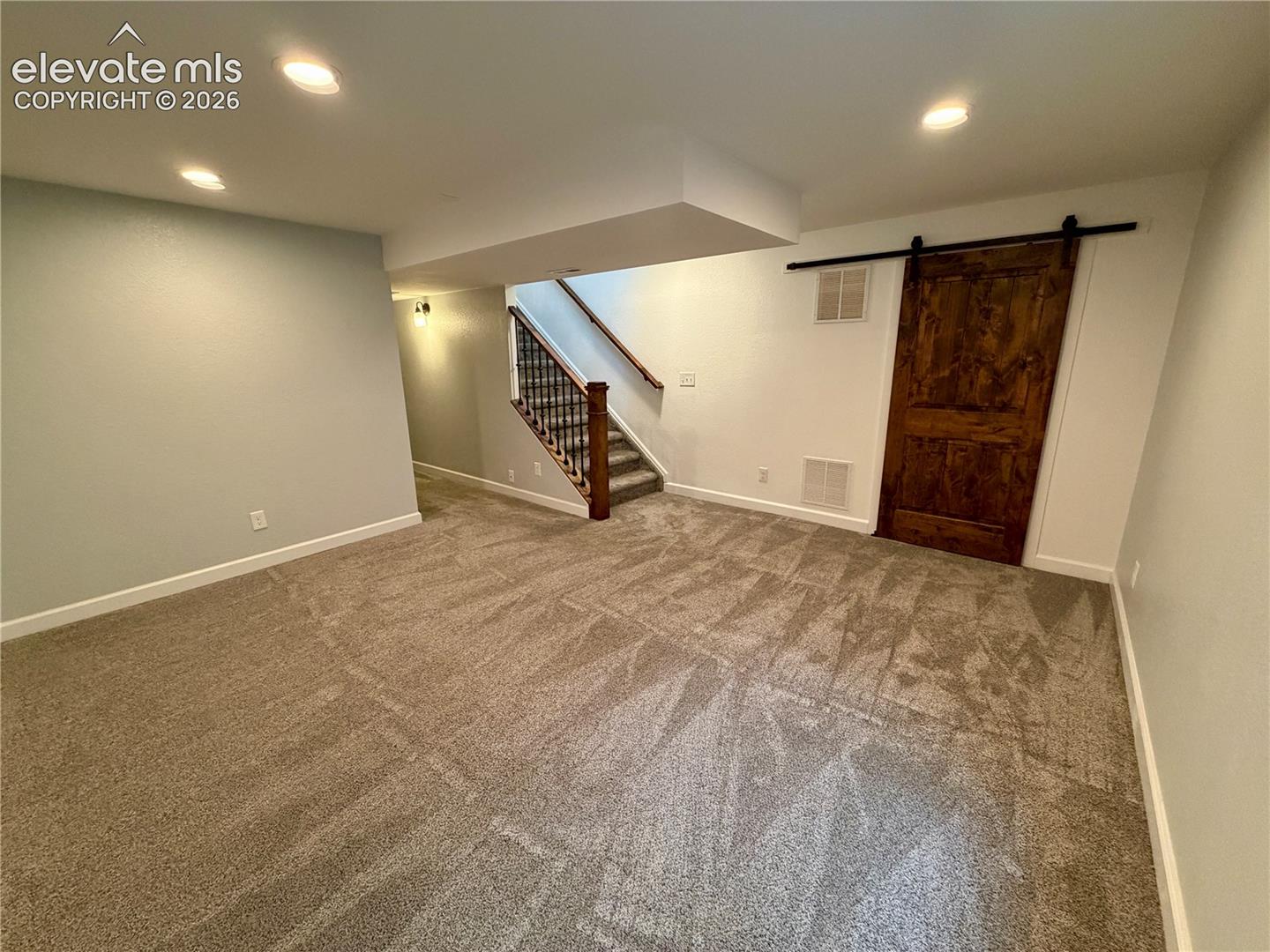 Spacious basement room (furniture removed) featuring neutral carpeting and recessed lighting