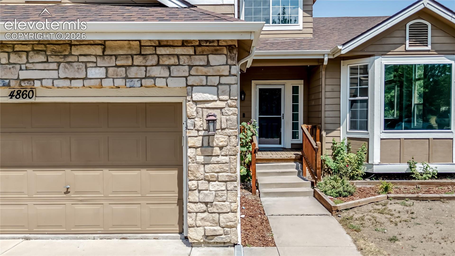 Stone veneer exterior accenting a panel garage door
