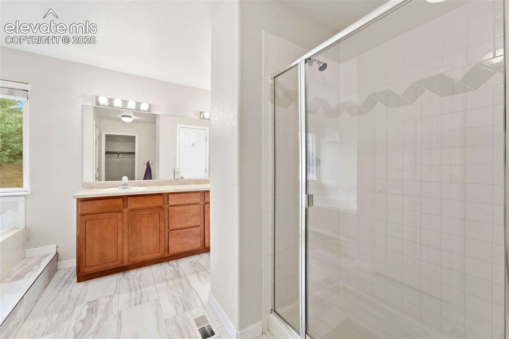 Primary Bathroom Features Tile Flooring and Spacious Walk In Shower