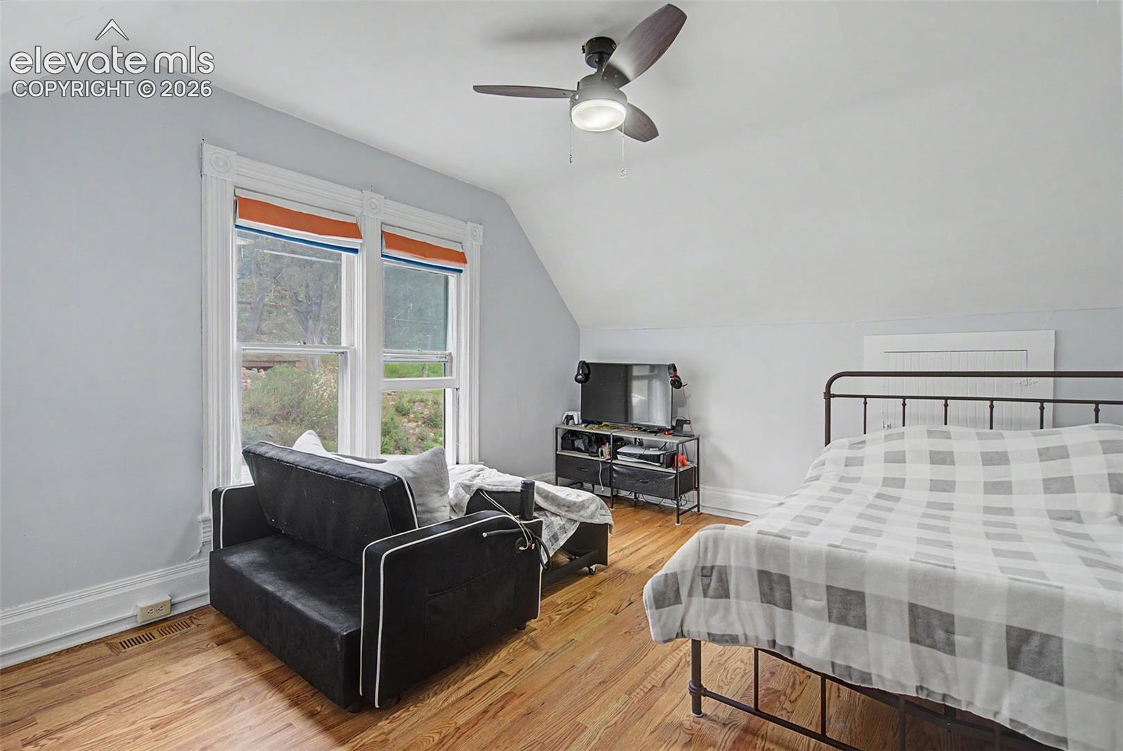 Upper bedroom featuring wood flooring and ceiling fan